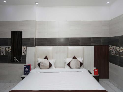 a bedroom with a bed with white sheets and pillows at Collection O Hotel RV Palace in Agra