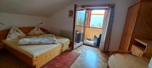 a small bedroom with a bed and a large window at Ferienhaus Waldhof in Hermagor