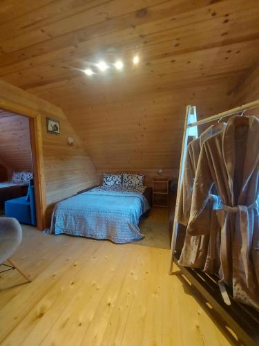 a bedroom with a bed in a wooden cabin at Lindiki in Salaspils