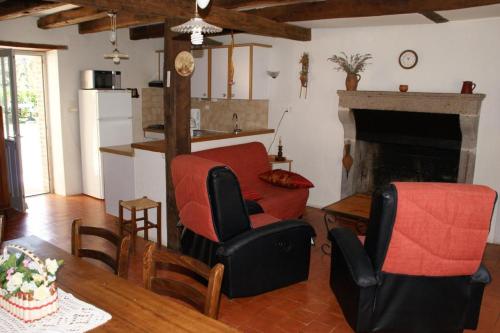 un soggiorno con tavolo, sedie e camino di Gites de la gartempe : saint-remy a Saint-Rémy-en-Montmorillon