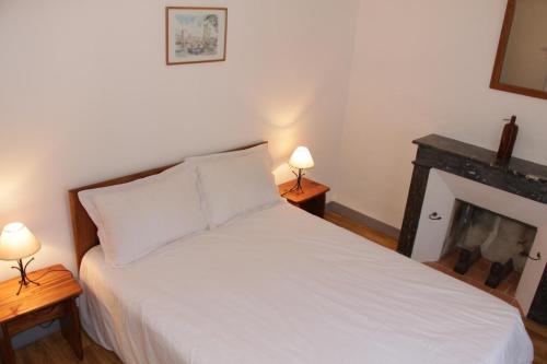 una camera con un letto bianco e due lampade di Gites de la gartempe : saint-remy a Saint-Rémy-en-Montmorillon