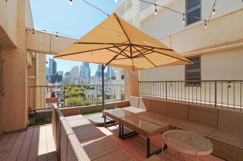 a patio with a table and umbrella on a balcony at V.Close to Shinjuku Kabukicho/Korean Town/FrWIFI C in Tokyo