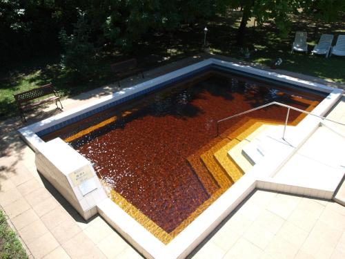 a swimming pool with a bench next to it at Árnyas Thermal Camping és Üdülőpark in Püspökladány