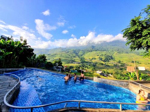 un grupo de personas en una piscina con montañas en el fondo en Tavan Chopai Homestay, en Sa Pa