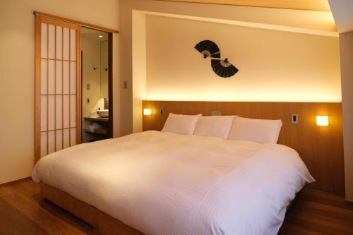 a bedroom with a large white bed and a mirror at Gion Misen in Kyoto