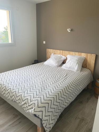 a bed with two pillows on it in a bedroom at La Villa des Vergers in Coulounieix-Chamiers