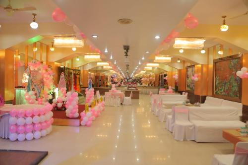 a banquet hall with pink and white tables and chairs at Hotel Maiden Residency in Ghaziabad