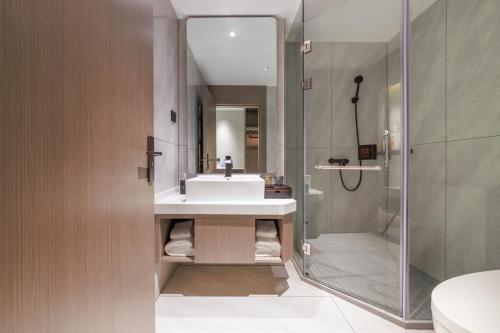 La salle de bains est pourvue d'un lavabo et d'une douche. dans l'établissement Feili International Hotel, à Canton