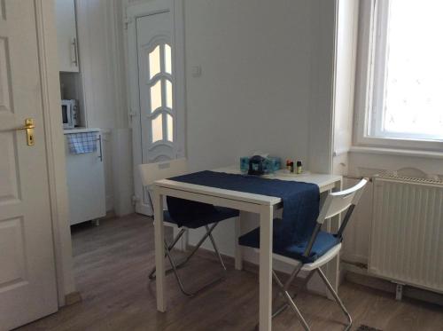 einen Tisch und Stühle in einem Zimmer mit Fenster in der Unterkunft Cozy in Budapest in Budapest