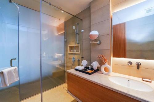 a bathroom with a sink and a glass shower at Anantam Resort & Spa in Kasauli