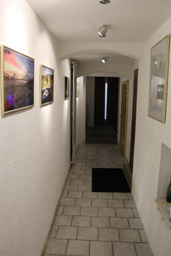 a hallway with paintings on the walls and a tile floor at Welcome-Home-Radeberg in Radeberg