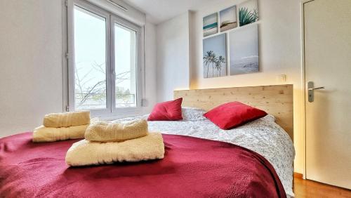- une chambre avec un grand lit et des oreillers rouges dans l'établissement ☆ Le Nid de Coton ☆ Balcon ☆ Calme ☆ Fibre ☆ Relax BNB ☆, à Pfastatt