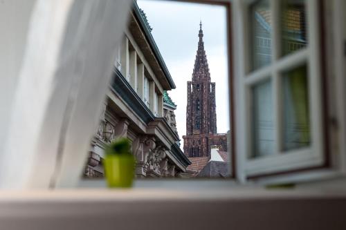 a view of a church steeple from a window at Hôtel Du Dragon in Strasbourg