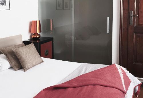 1 dormitorio con cama blanca y manta roja en ComeCasa Da Chiaretta, en Milán