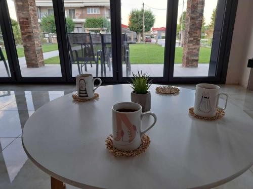 a white table with three coffee mugs on it at Golden Eagle House 