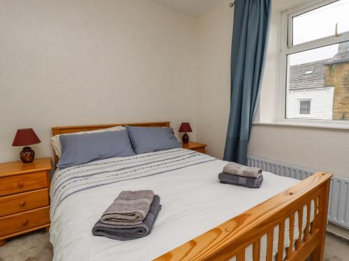 a bedroom with a bed with a wooden frame and a window at 28 Water Street in Skipton