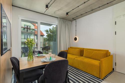 ein Wohnzimmer mit einem Tisch und einem Sofa in der Unterkunft GREEN PORT Apartament Lwowska with SWIMMING POOL Kołobrzeg by Renters in Kołobrzeg