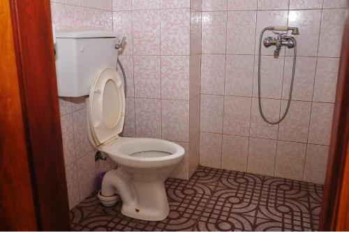 a bathroom with a toilet and a shower at Namulanda Motel in Entebbe