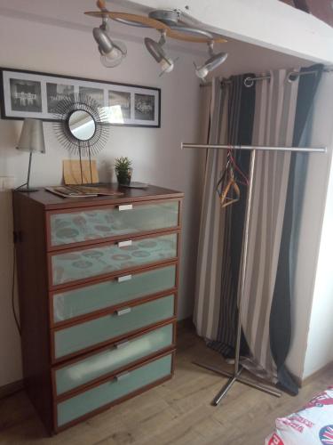 une chambre avec une commode et un miroir dans l'établissement chambre dans maison coquette et accueillante, à Dunkerque