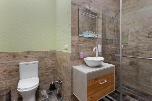 a bathroom with a toilet and a sink and a shower at Honeymoon Apartments in Old Tbilisi in Tbilisi City