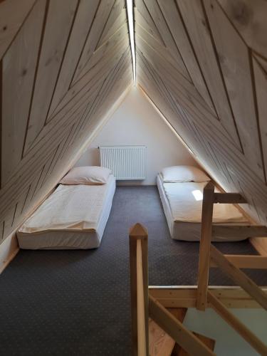 a room with two beds in a attic at Bajka w Gliczarowie in Bukowina Tatrzańska