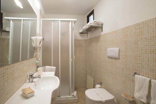 a bathroom with a toilet and a sink and a shower at Il Cortile Fiorito in Trapani