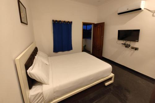 Cette petite chambre comprend un lit et une télévision. dans l'établissement DKV Beach View, à Bahūr
