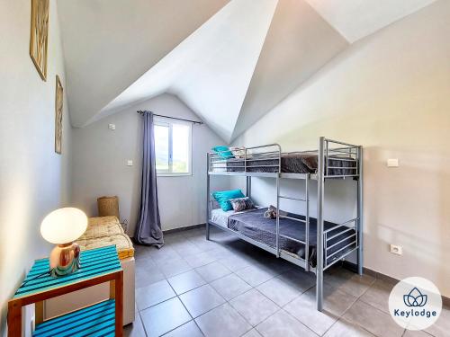 a room with bunk beds and a table and a lamp at Kazolie - maison F4 - 120 m2 - Sainte-Rose in Sainte-Rose