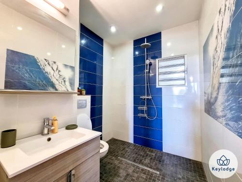 baño con paredes azules, aseo y lavamanos en Kazolie - maison F4 - 120 m2 - Sainte-Rose, en Sainte-Rose