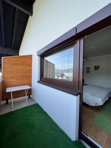a room with a window and a bedroom with green carpet at Apartment „Bergblick“ in Sankt Johann in Tirol
