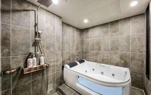 Seosan Hotel November في Seosan: حمام مع حوض استحمام ودش
