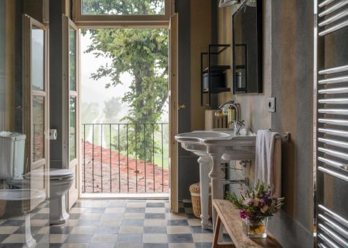 a bathroom with a sink and a door to a balcony at NEW! Vigne di Fagnano 1709 Eco Relais in Santo Stefano Belbo