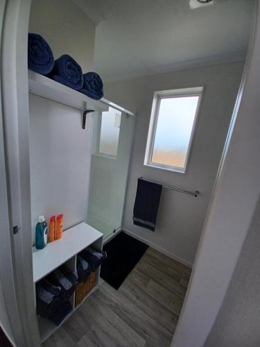 baño pequeño con lavabo y ventana en West Coast Wonder 4 Minutes Drive to Glinks Gully, en Te Kopuru