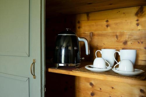 a tea kettle and cups on a counter at Vigne di Fagnano 1709 Eco Relais in Santo Stefano Belbo