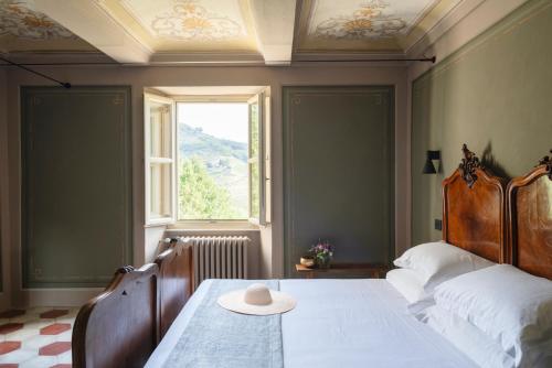 a bedroom with a bed with a hat on a table at NEW! Vigne di Fagnano 1709 Eco Relais in Santo Stefano Belbo