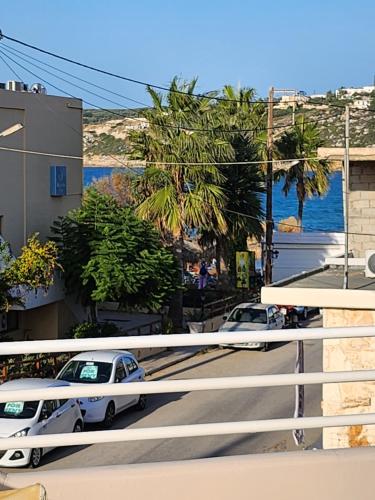 two cars parked on a street next to the ocean at Nora Apartment in Almyrida in Chania Town