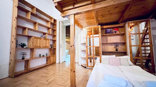 1 dormitorio con paredes de madera, 1 cama y estanterías en Ulloi Apartment - Unique Style near Corvin, en Budapest