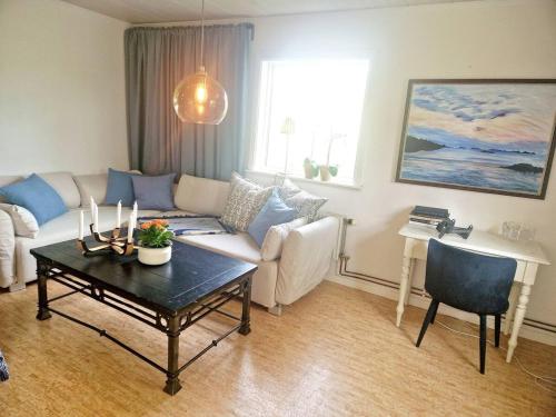 uma sala de estar com um sofá e uma mesa em Litet hus på gård med utsikt över indalsälven em Indal