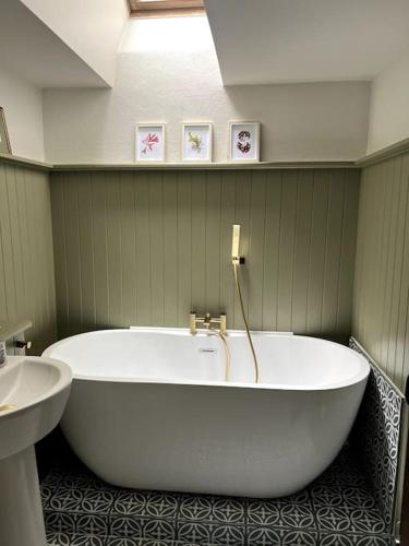 a large white tub in a bathroom with a sink at Bay Tree Barn in Truro