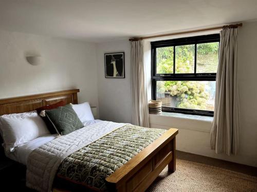 a bedroom with a bed and a window at Bay Tree Barn in Truro