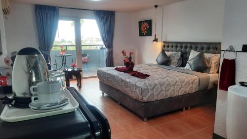 1 dormitorio con cama y mesa con licuadora en Happy Beach Jomtien Guesthouse, en Jomtien Beach