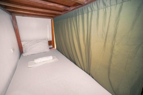 a small bed in a room with a green curtain at Chill Out Hostel in Boracay