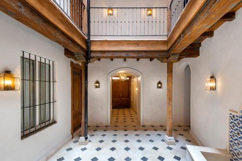 an empty hallway with a wooden ceiling and tile floor at Magno Apartments Casa Pilatos in Seville