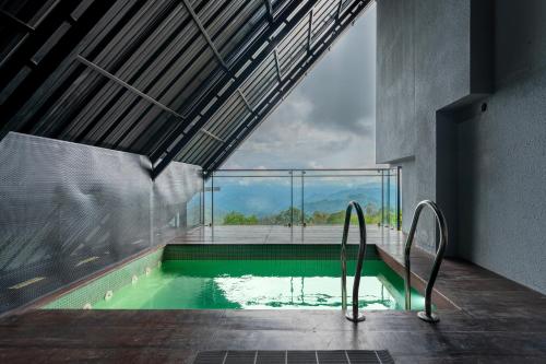 a swimming pool in a building with a large window at K Mansion in Munnar