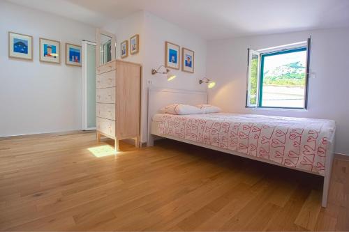 1 dormitorio con 1 cama con tocador y ventana en Apartments Baška, en Baška