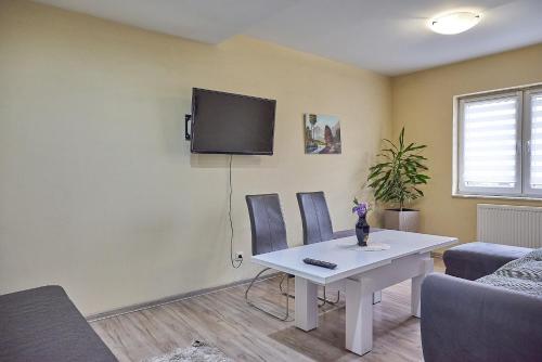 a living room with a table and a tv on the wall at Waldi Apartament Cieplice in Jelenia Góra