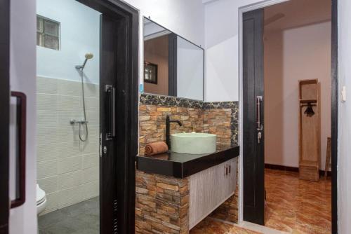 y baño con lavabo y espejo. en Asri Bali Sanur Apartment en Sanur