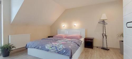 a bedroom with a bed with two pink pillows at Waldi Apartament Cieplice in Jelenia Góra