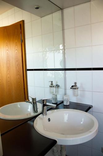 a bathroom with a white sink and a mirror at Private doublebed Room with balcony in shared house in Dornbirn