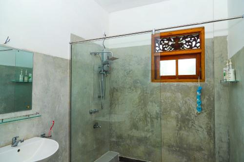 y baño con ducha y lavamanos. en Dil's Place en Beruwala